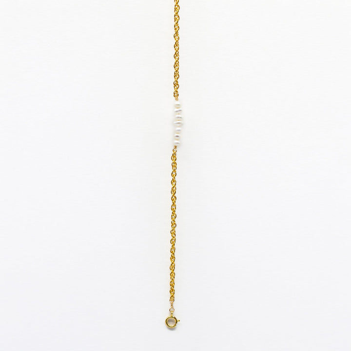 Gold necklace with small beads on a white background