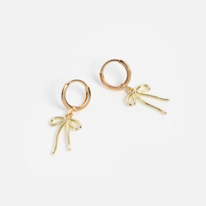 Gold hoop earrings with bow-shaped charms on a white background