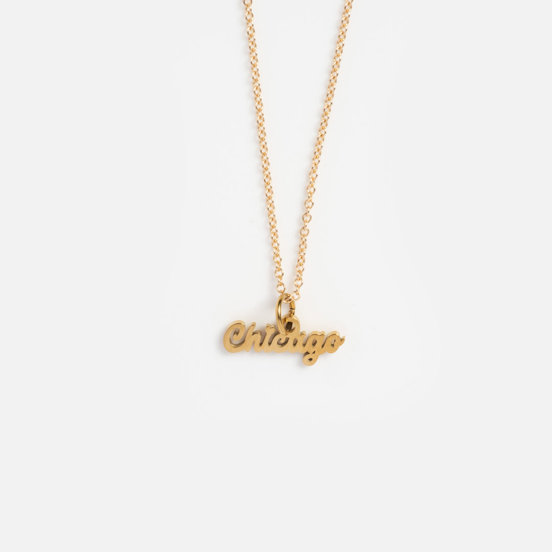 Gold necklace with 'Chicago' pendant on a white background