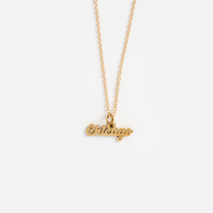 Gold necklace with 'Chicago' pendant on a white background