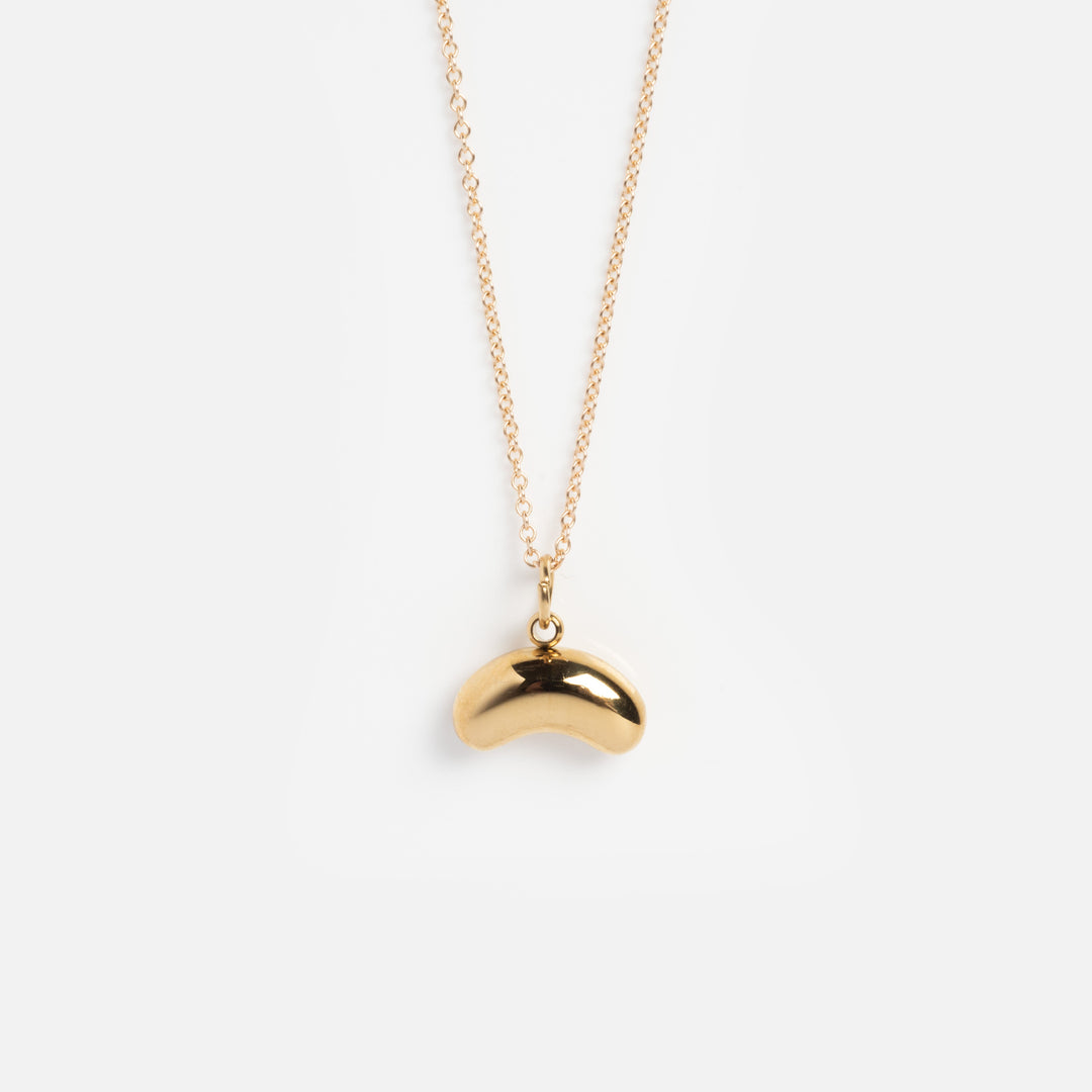 Gold necklace with a crescent moon pendant on a white background