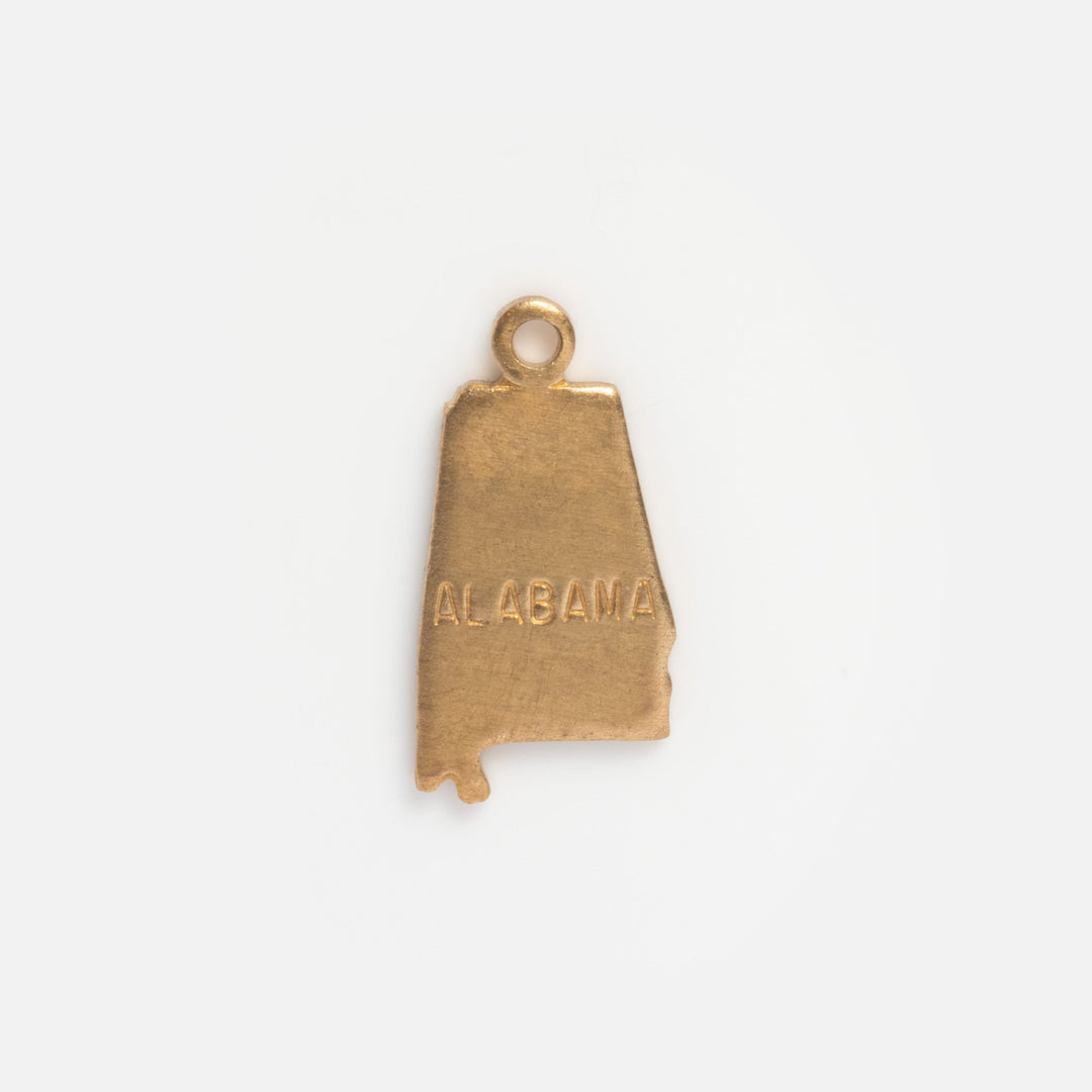 Gold pendant shaped like the state of Alabama on a white background