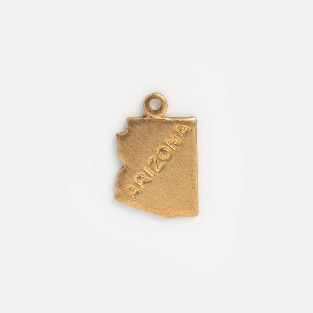 Gold pendant shaped like the state of Arizona on a white background