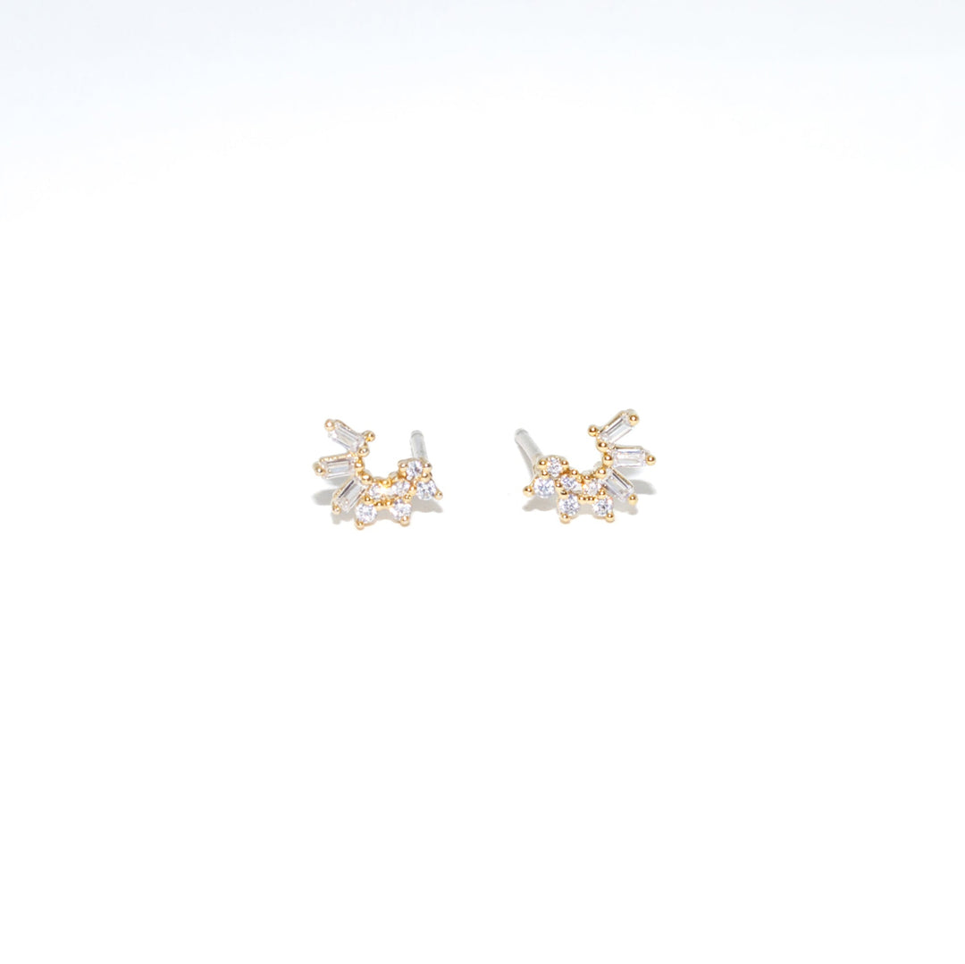 Pair of gold and crystal stud earrings on a white background