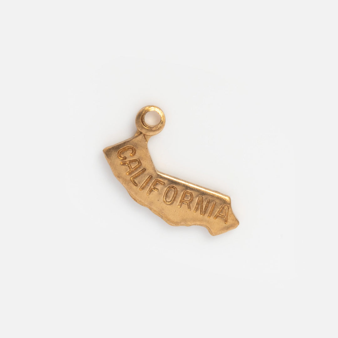 Gold charm shaped like the state of California on a white background