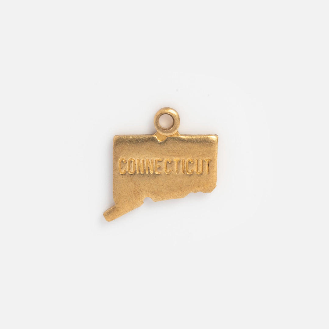 Gold charm shaped like the state of Connecticut on a white background