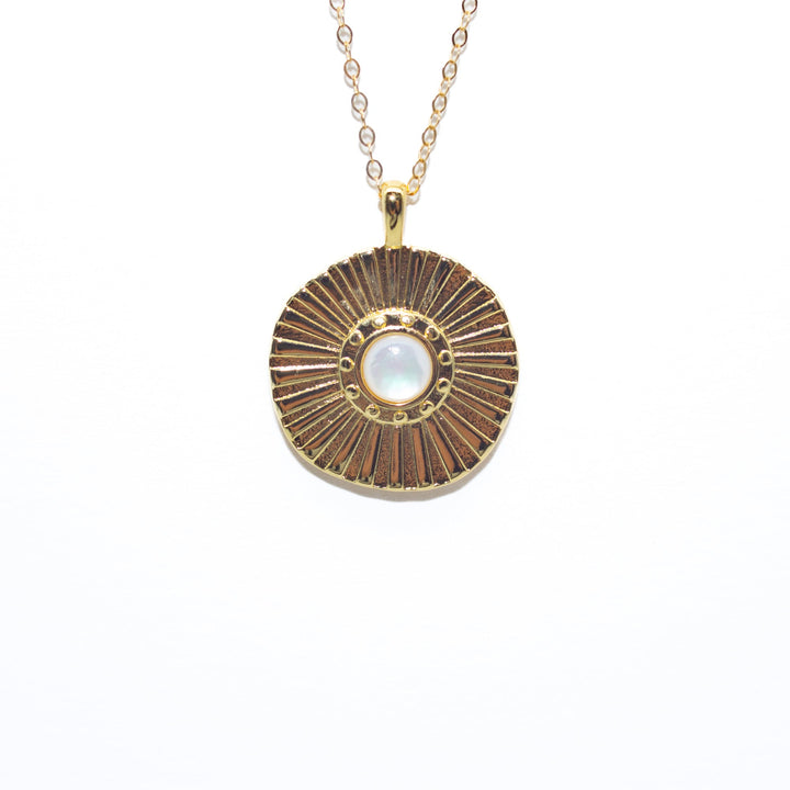 Necklace with a round pendant featuring a central pearl on a white background