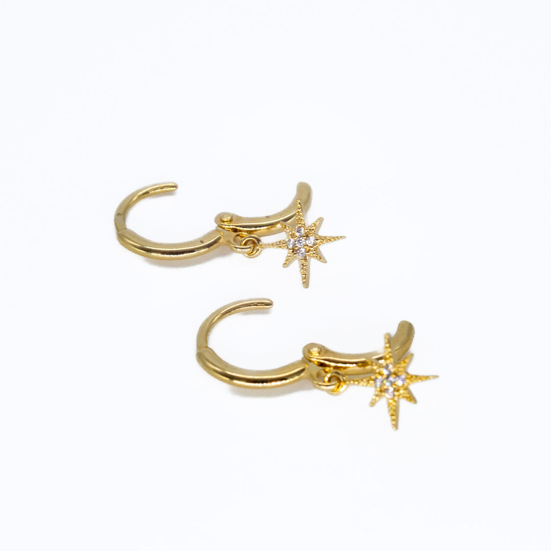 Pair of gold hoop earrings with star designs on a white background