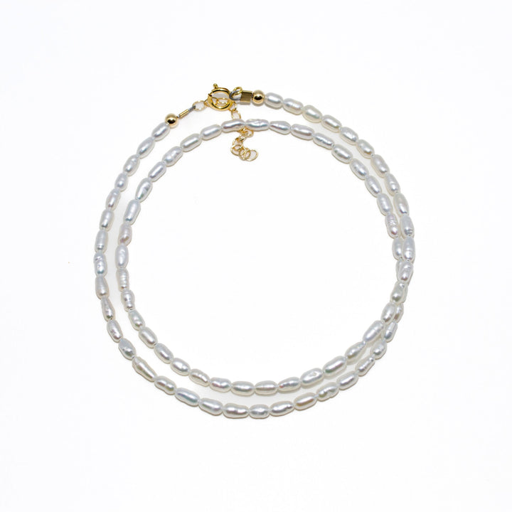 Pearl necklace with gold clasp on a white background