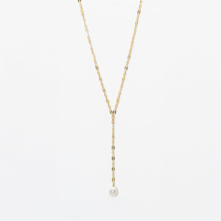 Gold necklace with a single pearl pendant on a light gray background
