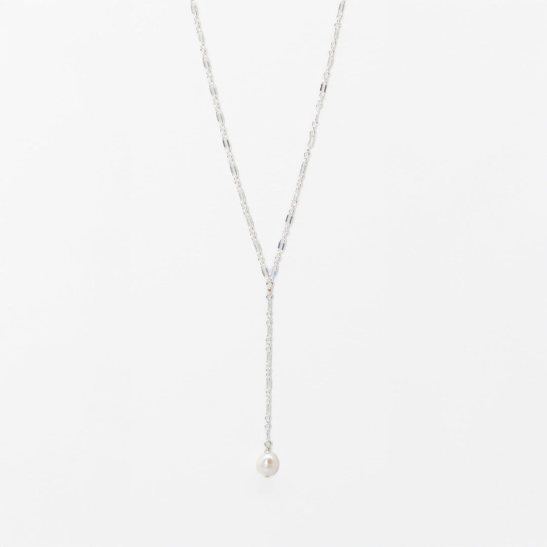 Silver necklace with a pearl pendant on a light gray background