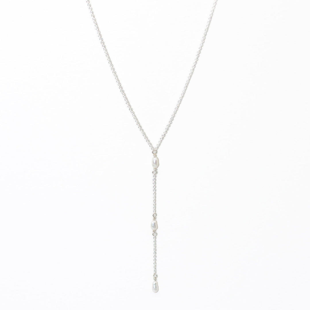 Silver necklace with pearl drops on a white background