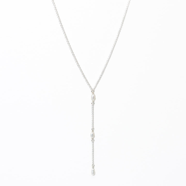 Silver necklace with pearl drops on a white background