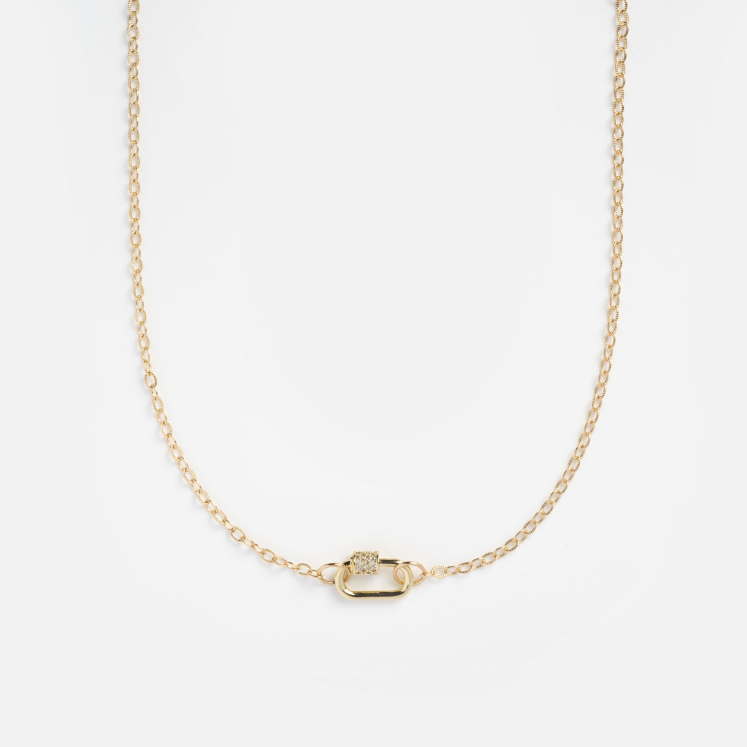 Gold necklace with a small pendant on a light gray background