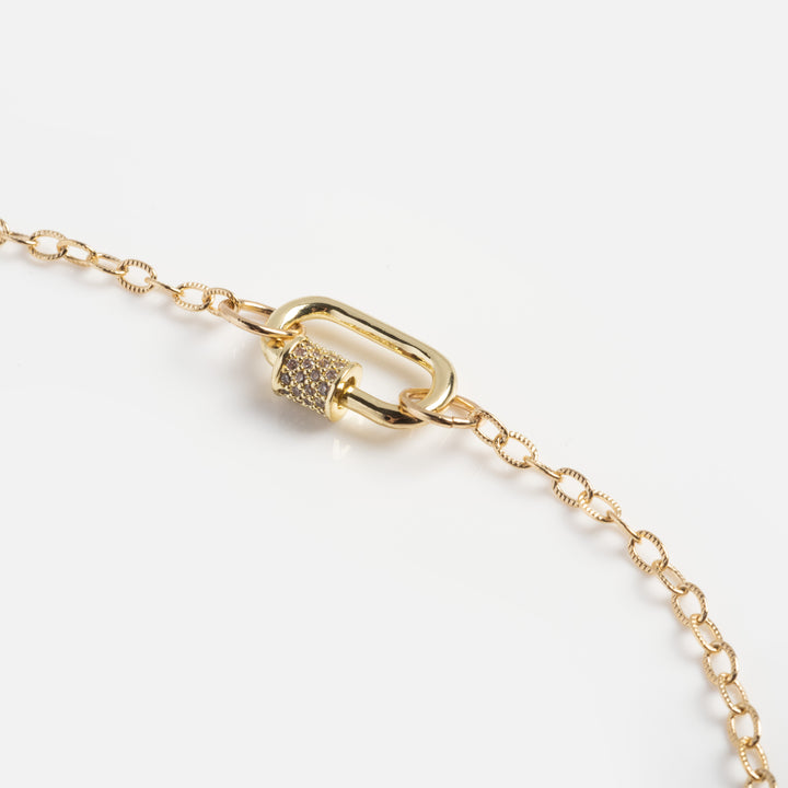 Gold bracelet with a clasp on a light gray background